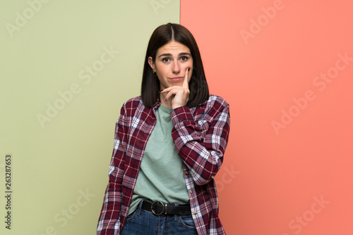 Young woman over isolated colorful wall Looking front © luismolinero