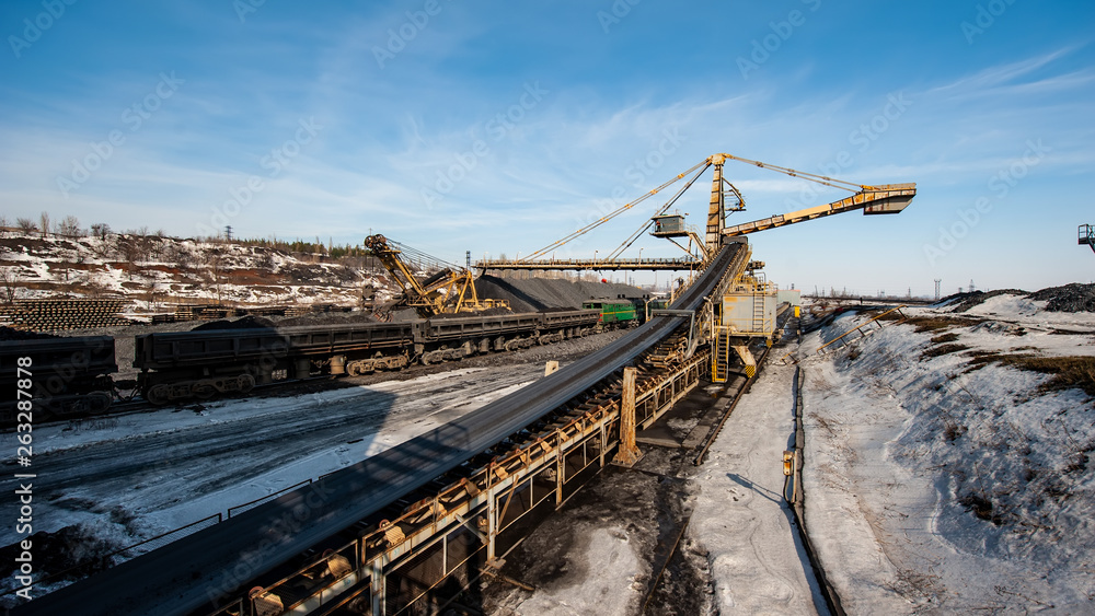Delivery of Iron ore by a Conveyor Belt from a Warehouse and Loading into Railway Dump Cars. Delivery of Iron ore by a Conveyor Belt from a Warehouse and Loading into Railway Dump Cars.