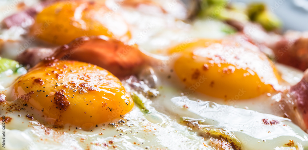 English breakfast fried bacon ham and eggson white plate