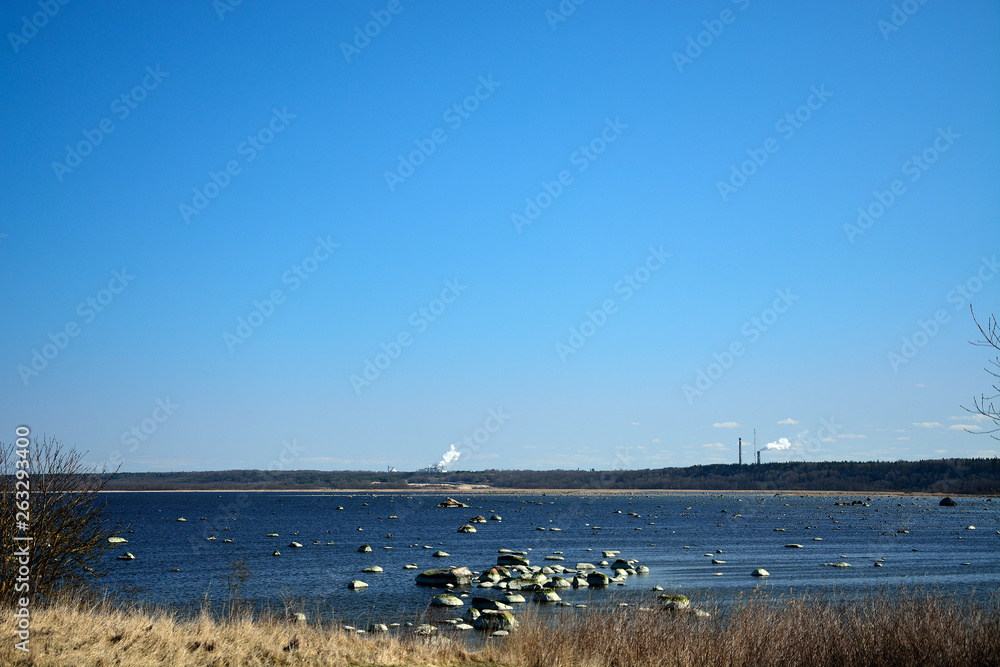 Landscape of the Baltic Sea. Smoke factory overseas.