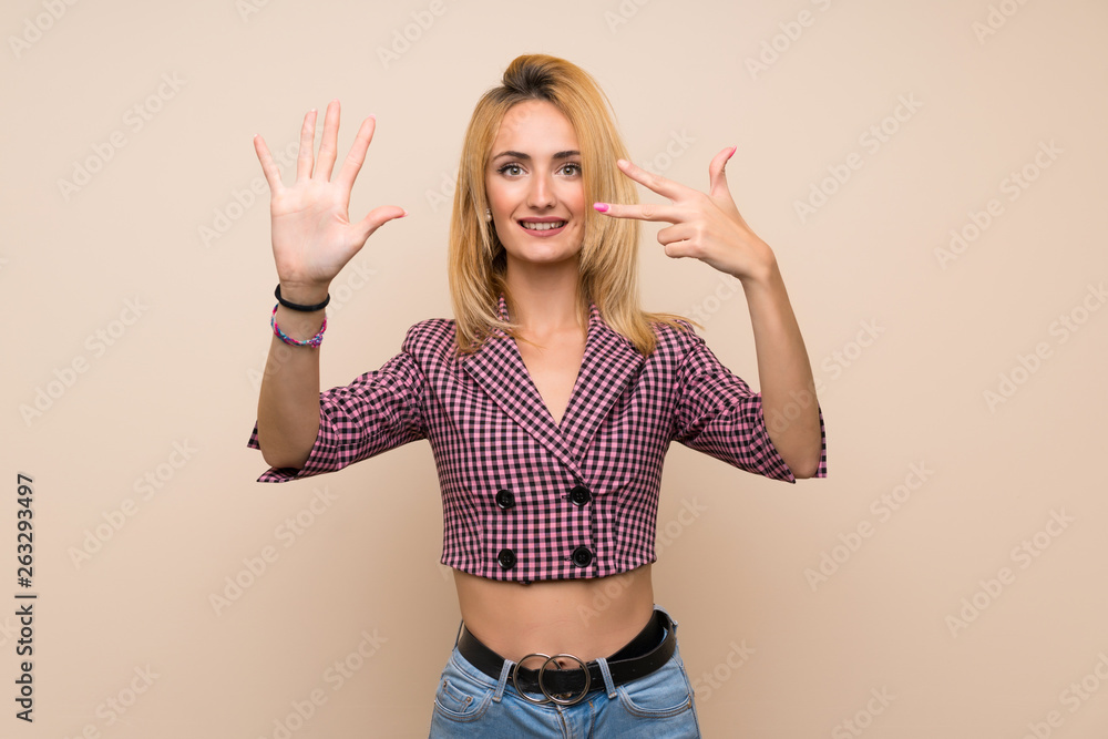 Young blonde woman with pink jacket over isolated wall counting eight with fingers Young blonde woman with pink jacket over isolated wall counting eight with fingers