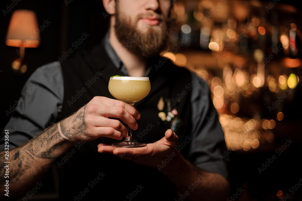 Close shot of bartender holding cocktail in his hands Close shot of bartender holding cocktail in his hands
