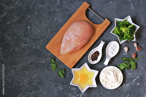 ngredients for cooking chopped chicken cutlets or rissole with broccoli: raw chicken, broccoli, wheat flour, egg, salt, pepper, garlic, parsley. Top view, copy space. photo