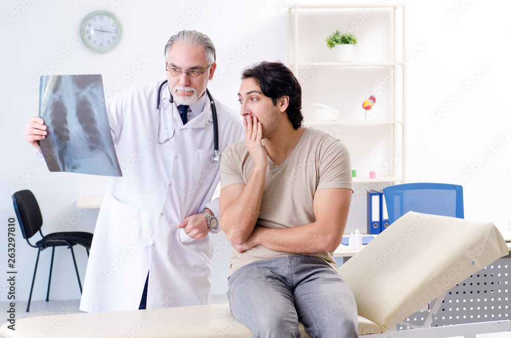 Fototapeta premium Young man visiting old male doctor radiologist 