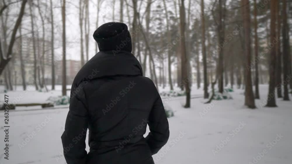 Young happy girl in black fur coat blowing on snow in the Park. Winter vacation. Portrait of happy girl in winter Park, she plays with snow. Young happy girl in black fur coat blowing on snow in the Park. Winter vacation. Portrait of happy girl in winter Park, she plays with snow.