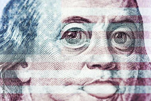 Big eyes of Benjamin Franklin with a hundred dollar bill, a symbol of inflation, appreciation, devaluation, close-up