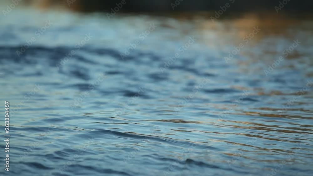 Relaxing image of water rippling at sunset - rack focus through layers of water. Relaxing image of water rippling at sunset - rack focus through layers of water.