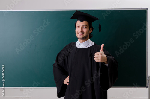 Graduate student in front of green board 