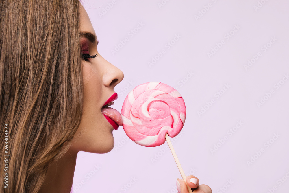 Sexy girl eating lollipop. Beauty Glamour Model woman Licking sweet  colorful lollipop candy, close-up. Closeup mouth and tongue. Seductive lips,  perfect fashion make-up, pink color lipstick Stock-foto | Adobe Stock