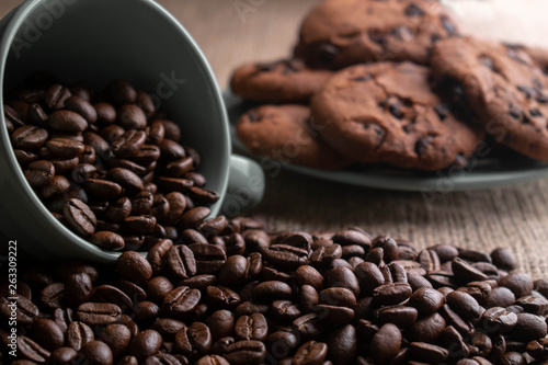 coffee beans crumbled with a cup, in the background a plate of cookies photo