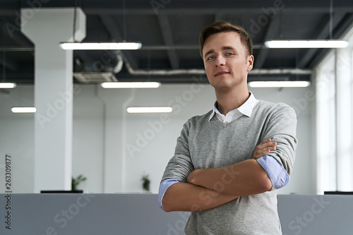 Free Download Portrait of a handsome young man professional with arms crossed looking at camera in the IT company office - GFXLoad