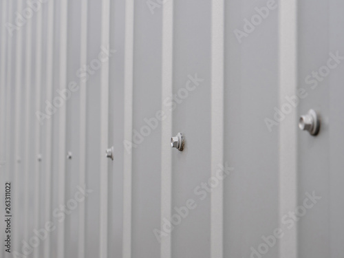 Close up photo. grooved metal surface texture, galvanized steel background with bolts © Neis