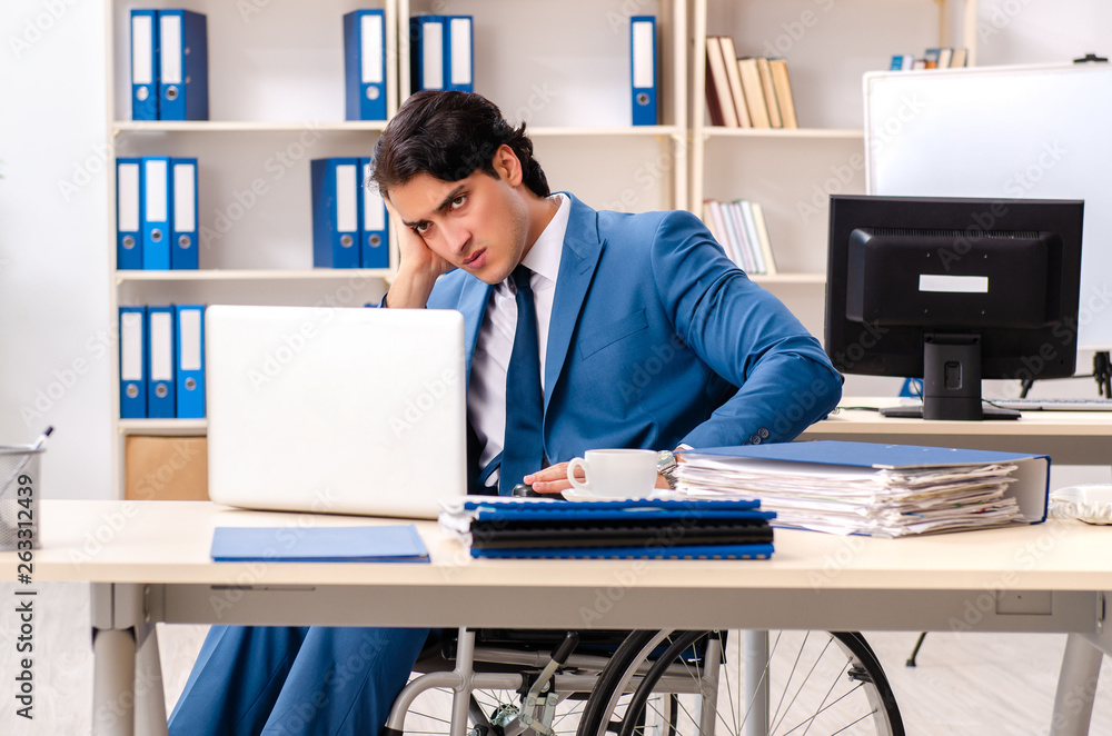 Male employee in wheelchair working at the office Male employee in wheelchair working at the office