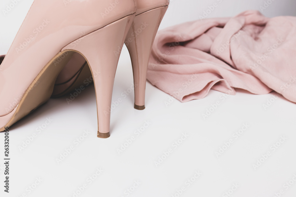 Fashionable concept, pastel beige shoes with high hills and delicate blouse on white background, sale, diascount and shopping concept with copy space Fashionable concept, pastel beige shoes with high hills and delicate blouse on white background, sale, diascount and shopping concept with copy space