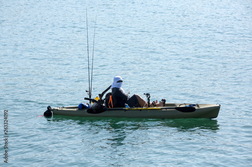 Person in a small boat heads out to fish in the bay
