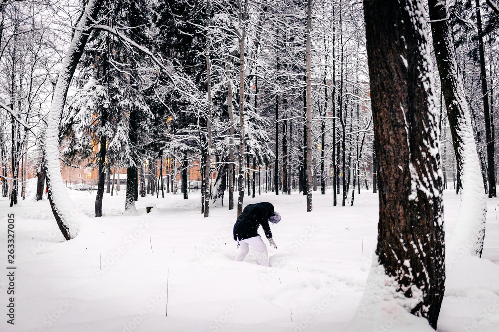 girl in a black jacket and white pants crawling through the snowdrifts girl in a black jacket and white pants crawling through the snowdrifts