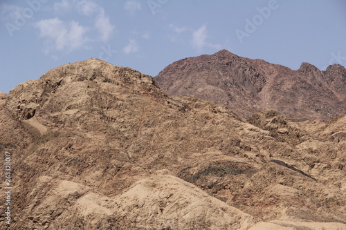 desert mountains lit by the sun against the blue sky