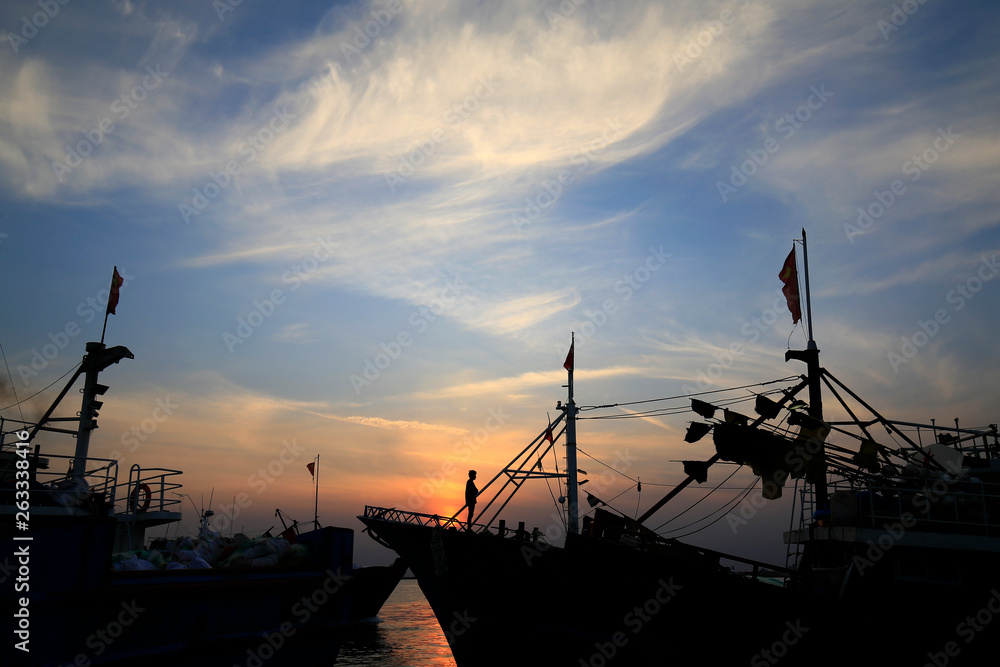 Fishing boats silhouetted against the setting sun