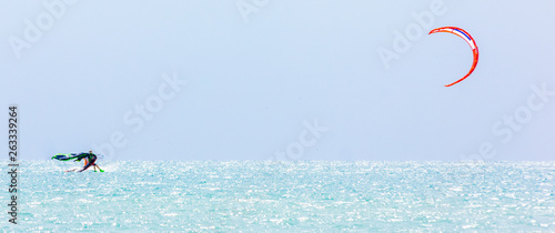 brave man kite sailing on the black sea with a sail wing in his hands led by the wind on a bright sunny day. village of the annunciation. сopy space.