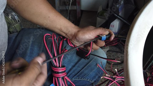 4K Video Selective focus medium shot of men hands use screwdriver make audio speaker cable with speakon connectors. Technician making sound speaker plugin cable by handmade. photo