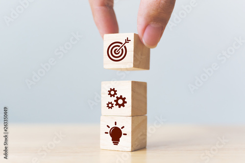 Concept of business strategy and action plan. Businessman hand putting wood cube block on top with icon photo