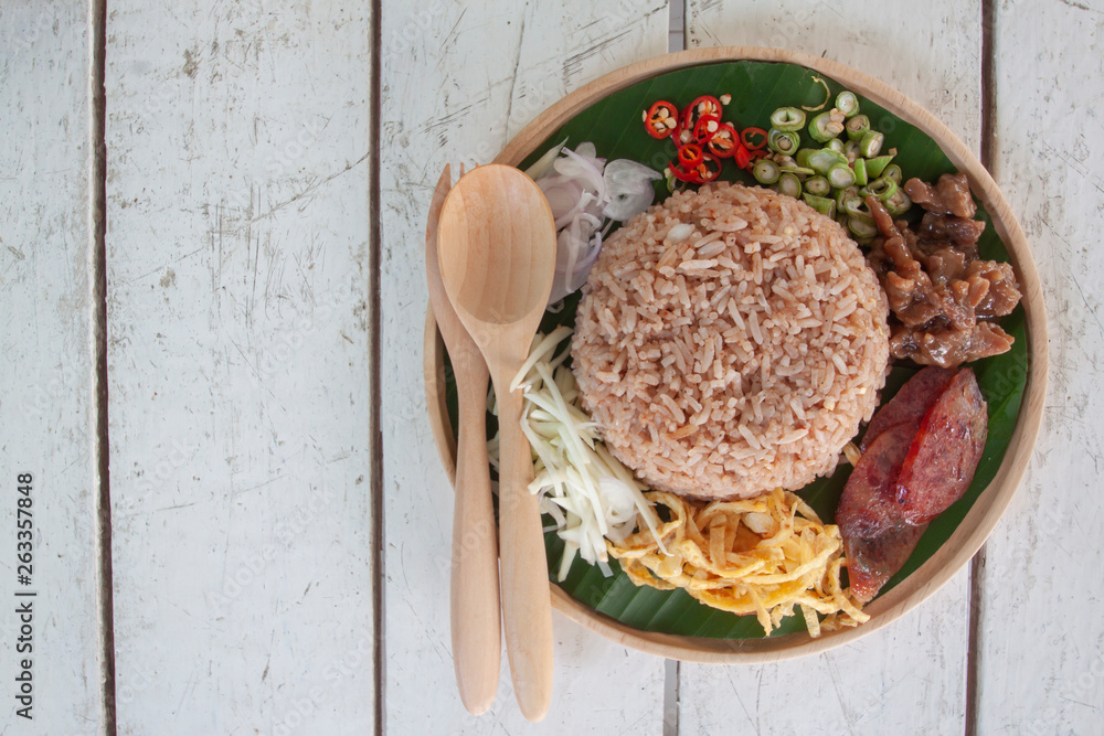 Rice mixed with shrimp paste Thai people call Kao Cluk Ka Pi on white wooden table. - obrazy, fototapety, plakaty 
