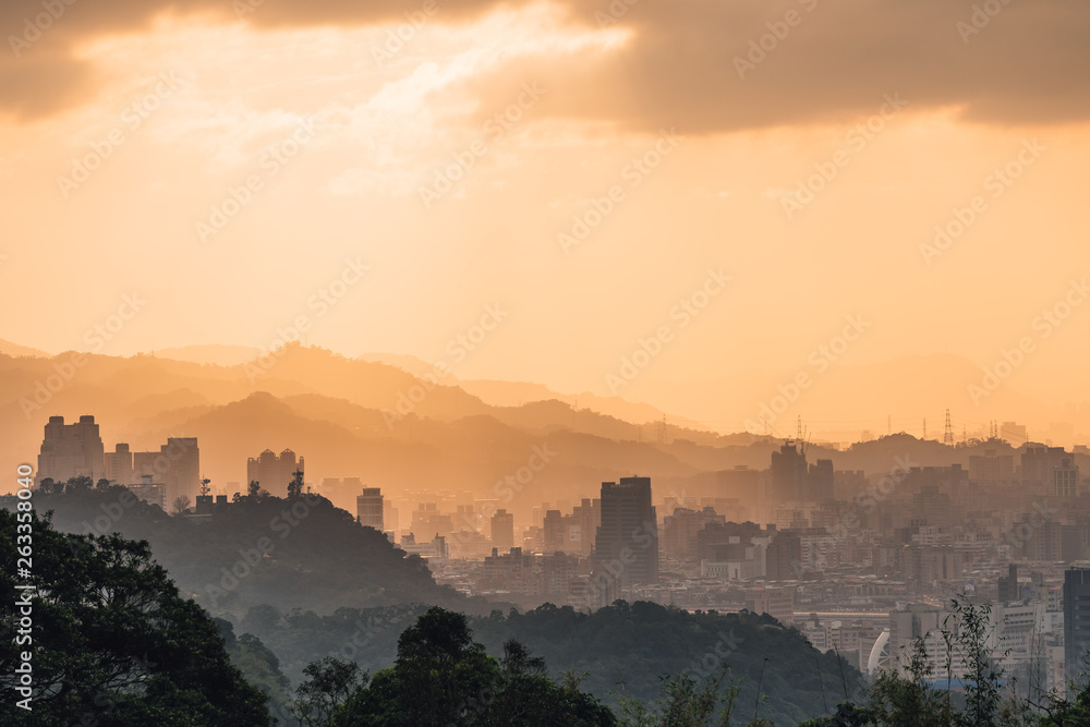 Layers of Taipei cityscape and mountains with sunlight when the sun going down that view from Xiangshan Elephant Mountain in the evening in Taipei, Taiwan.