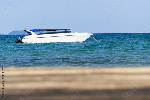 Speedboat is floating over the sea with blur sand beach in foreground in summer in Koh Mak Island at Trat, Thailand.