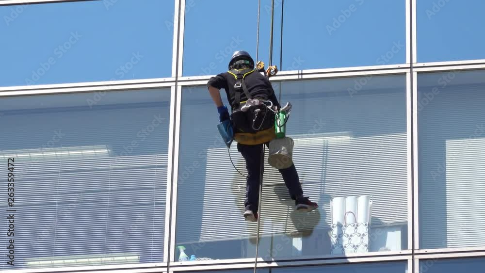 4K Workers wipe the glass of tall buildings Work on high places using rope laces for safety. 4K Workers wipe the glass of tall buildings Work on high places using rope laces for safety.