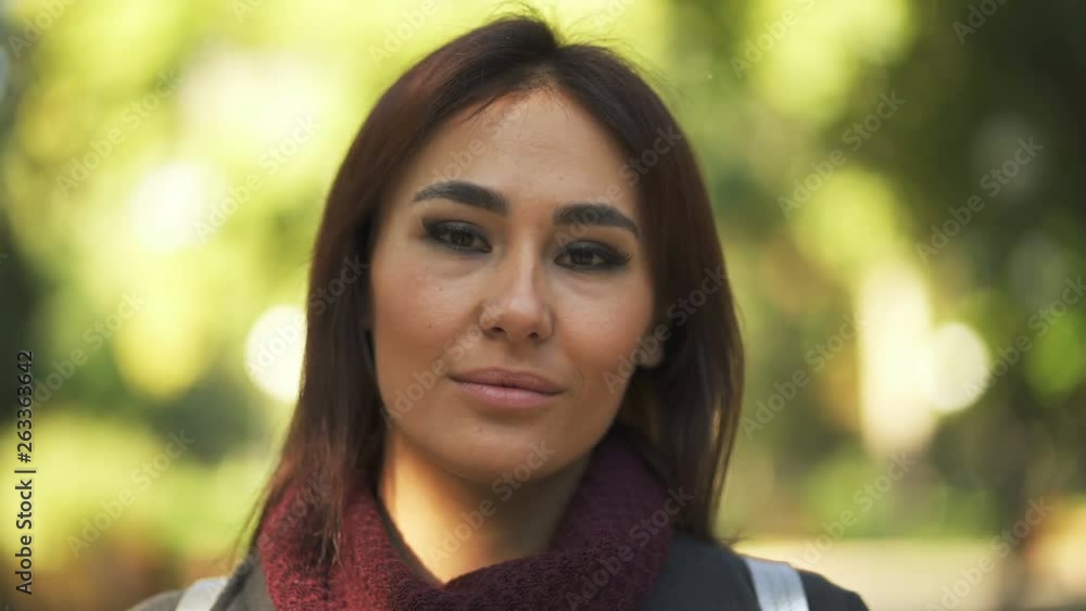 4k. Face of young attractive Asian woman in sunny city park. Portrait 4k. Face of young attractive Asian woman in sunny city park. Portrait