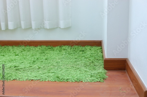 green carpet covering on laminate wooden floor