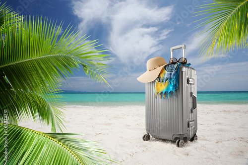 view of  suitcase with hat  pareo and sunglasses on sunny tropic beach