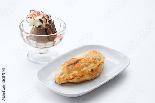 close up view of nice yummy empanada with ice cream on white table