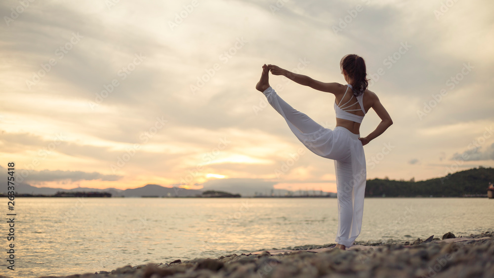 Rear view of healthy women practicing yoga. standing near sea. exercise Extended Hand to big toe Pose.Utthita Hasta Padangustasana.   .beautiful landscape view sky on morning,copy spare for text