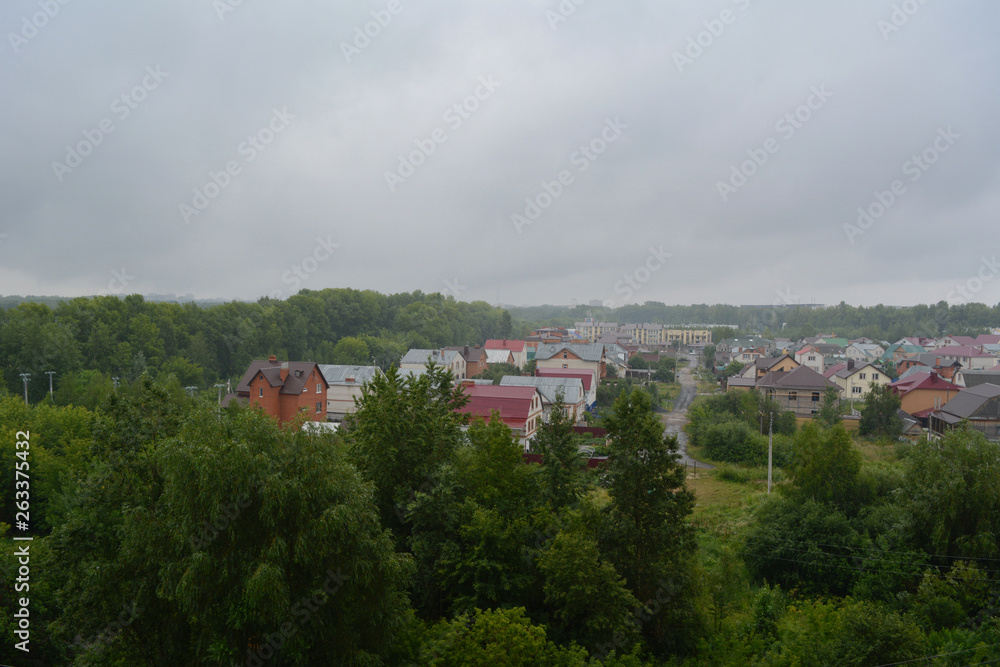 It's raining. View from top on small town with houses and trees.