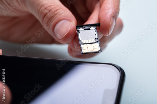 Person Inserting Sim Card In Cellphone
