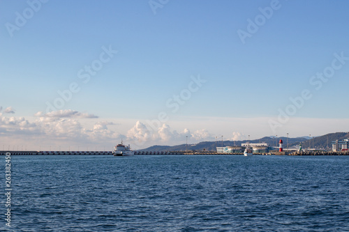 View of the city coast from the sea, lighthouse, ship © nellino7