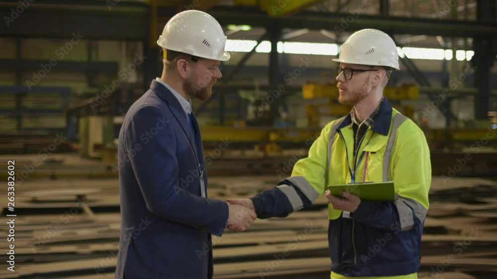 Manufacturing inspector shaking hands with factory manager Manufacturing inspector shaking hands with factory manager