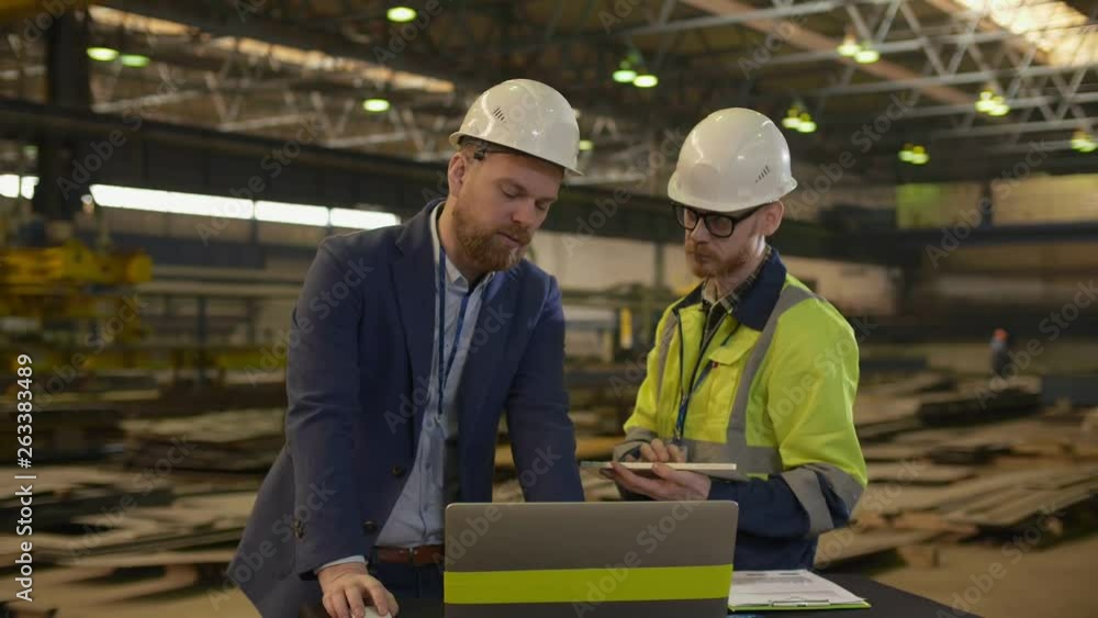 Two Engineers Using CAD Programming Software On Laptop Two Engineers Using CAD Programming Software On Laptop