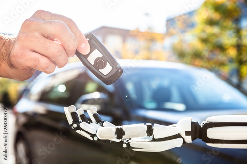 Man Giving Car Key To Robot