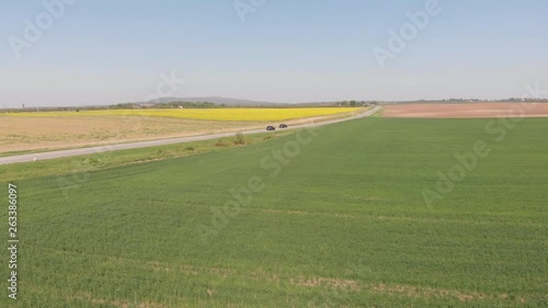 Drone 4k video of green field in nature near the road on windy day
