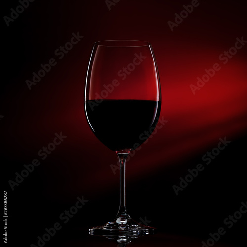 Silhouette of glass of red wine on black to red gradient background. Close-up studio shot.