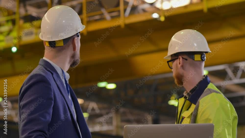 The man in the suit and the helmet talking to the worker The man in the suit and the helmet talking to the worker