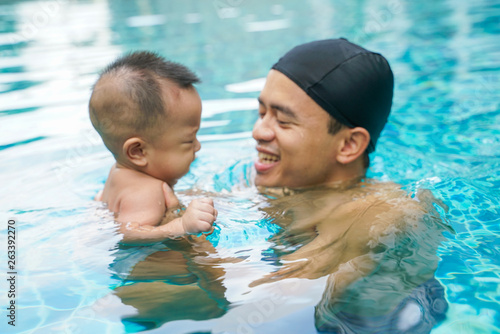 Father swimming with adorable little baby boy