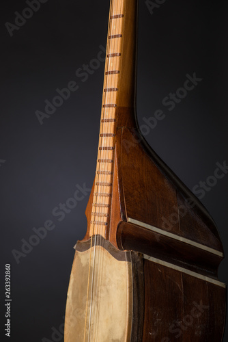 part ancient Asian stringed musical instrument on black background with backlight photo