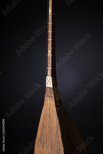 part ancient Asian stringed musical instrument on black background with backlight photo