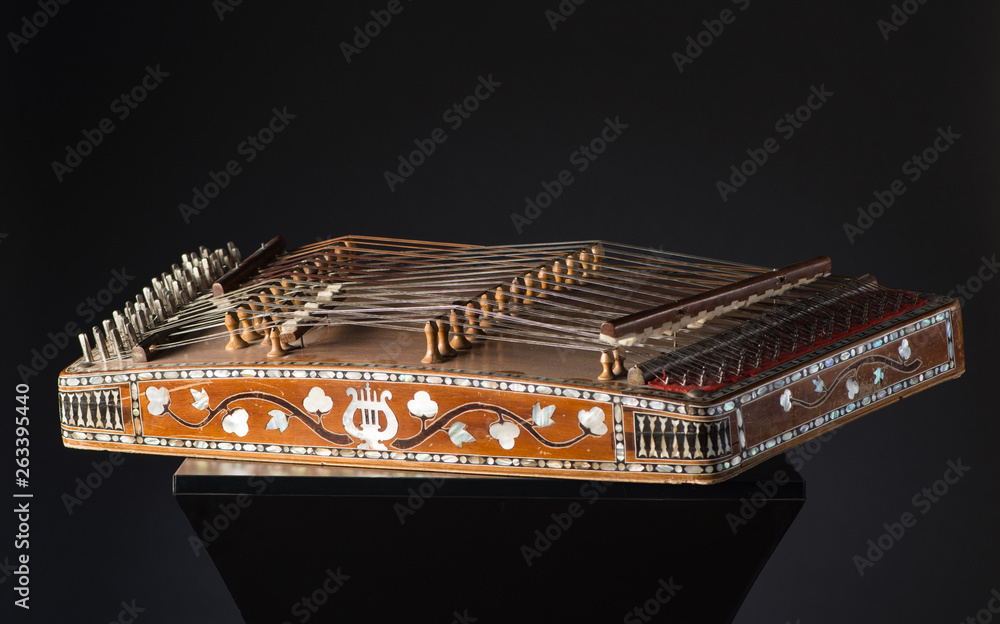 ancient Asian stringed musical instrument on black background with backlight. the similarity of the harp and psaltery