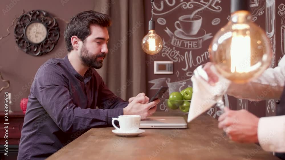 Young man at a bar counter looks at his smartphone screen. Handsome man at a bar counter checking social media. Young man at a bar counter looks at his smartphone screen. Handsome man at a bar counter checking social media.