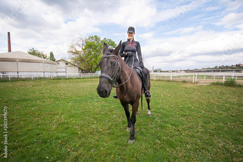 Young woman riding a horse, training it and preparing it for the hippodrome races