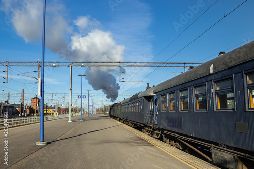 Kouvola, Finland - April 18, 2019: Old steam train Ukko-Pekka is leaving the station at morning. photo